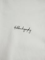 左胸に配置されたHOKKAIDOGRAPHYの筆記体ブランドロゴ。シンプルで洗練されたワンポイントデザイン。