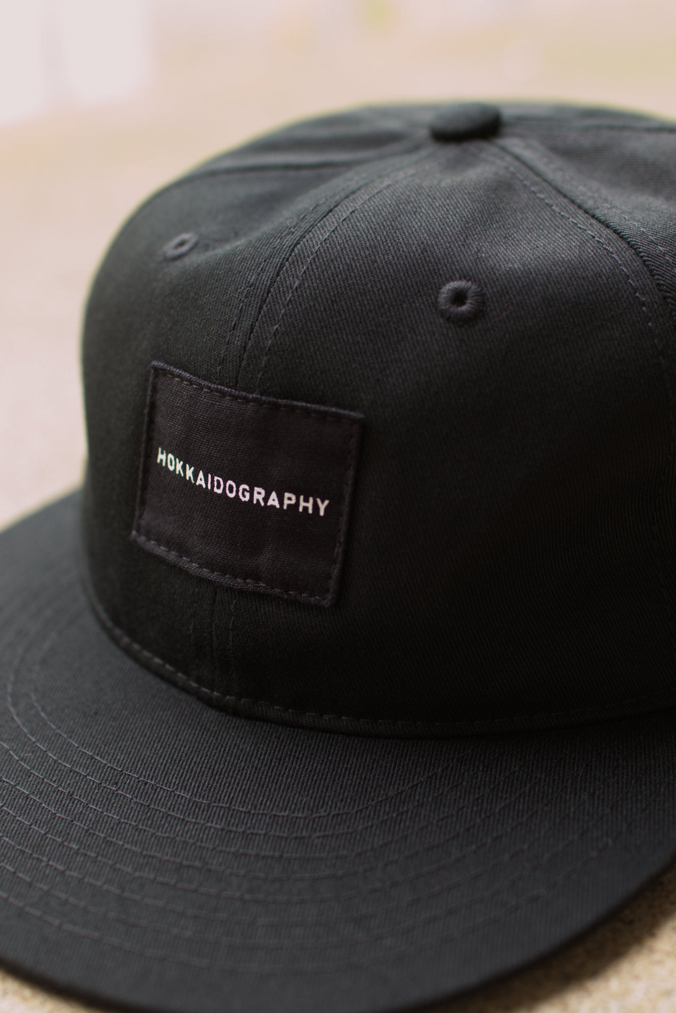 HOKKAIDOGRAPHY RETRO キャップ ブラック フロント タイポグラフィロゴ クローズアップ