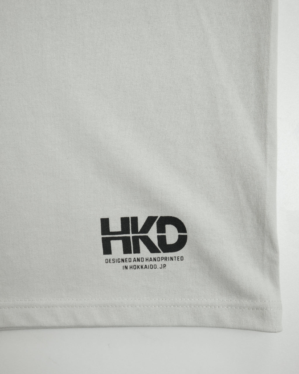 MONO TREE Tシャツ フロストグレー 左裾 HKDロゴ クローズアップ